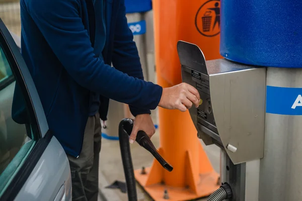 Persona que paga monedas a la máquina automática del vacío del coche del autoservicio —  Fotos de Stock