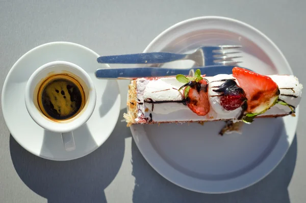 Xícara ensolarada de café e bolo no café na mesa fora do terraço fundo — Fotografia de Stock