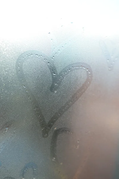 Coração de amor pintado em vidro. O vidro está embaçado e há muitas gotas nele. — Fotografia de Stock