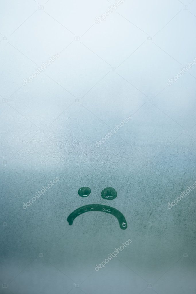 Sad smile inscription on the foggy glass