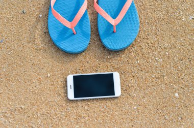 Closeup smartphone cep telefonu ile sahilde. Üst görüntülemek düz yatıyordu stili