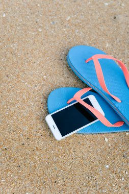 Closeup smartphone cep telefonu ile sahilde. Üst görüntülemek düz yatıyordu stili