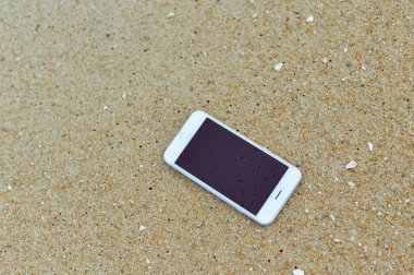 Closeup smartphone cep telefonu ile sahilde. Üst görüntülemek düz yatıyordu stili