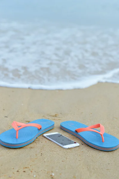 Widok z góry z bliska na telefon komórkowy z klapki na lato na tle plaży. Szczęśliwy radosny wakacji — Zdjęcie stockowe