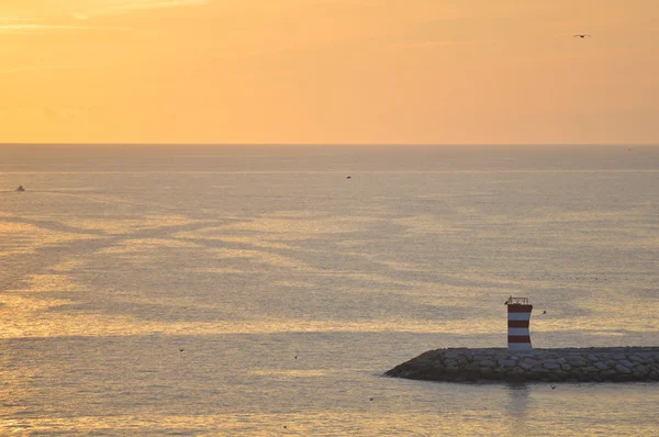 Hermoso paisaje marino con faro y cielo malhumorado al amanecer o al atardecer — Foto de Stock