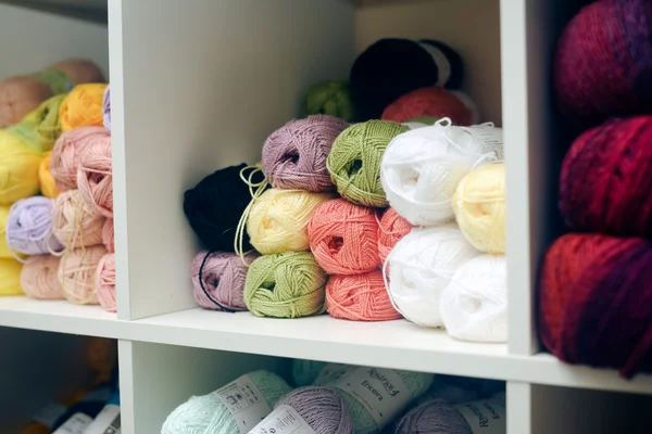 Kleurrijke ballen van wol opgestapeld op plank — Stockfoto