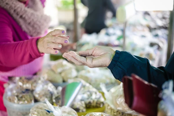 Compradores y vendedores manos en fondo colorido al aire libre — Foto de Stock