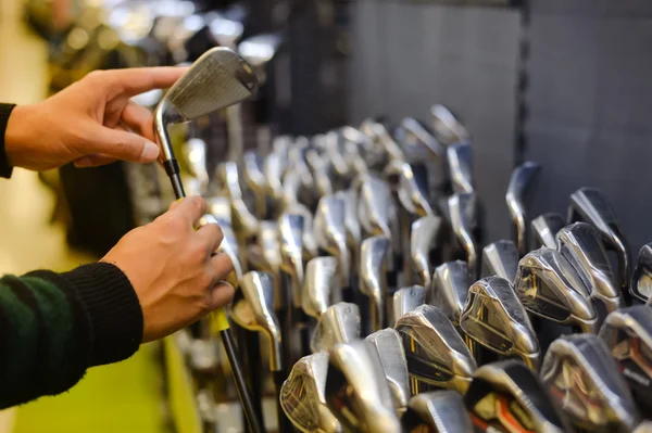 Человек, держащий клюшку для гольфа в магазине гольфа — стоковое фото