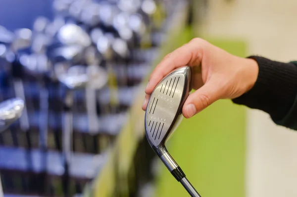 Personne tenant avec la main club de golf dans un magasin de golf — Photo