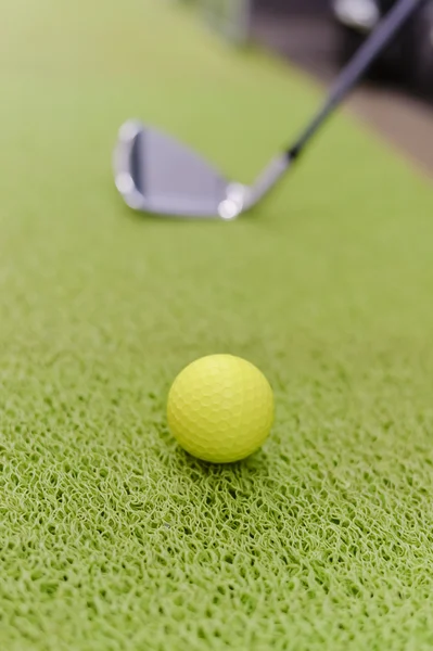 Playing indoors. Golf club and ball on green carpet grass background. — Stock Photo, Image