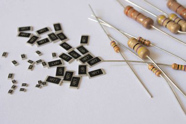 Çeşitli tipte direnişçiler, hem delikten hem de SMD yüzeyden, beyaz arka plana yerleştirilmiş. Elektronik, mühendislik ve elektronik devre tasarım bileşenleri kavramı.