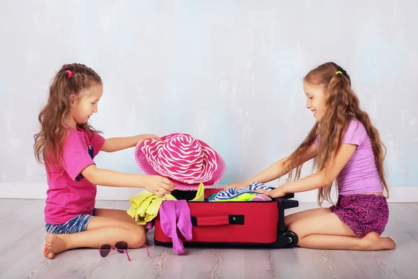 Две сестры забирают чемодан в путешествие — стоковое фото