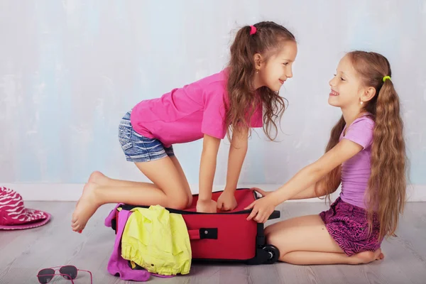 Дети играют и смеются с чемоданом — стоковое фото