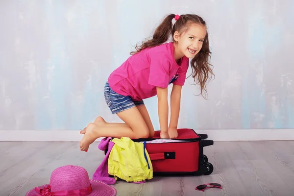 Šťastná holčička sedí na kufru — Stock fotografie
