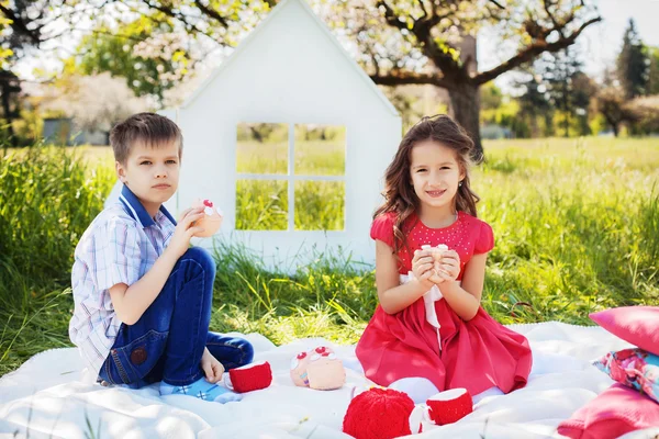 A gyermekek egy piknik a buja kertben — Stock Fotó