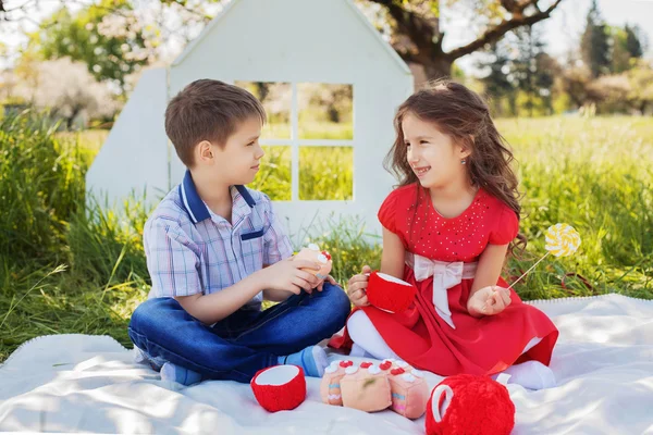 Маленькая девочка в платье улыбается мальчик на пикник — стоковое фото