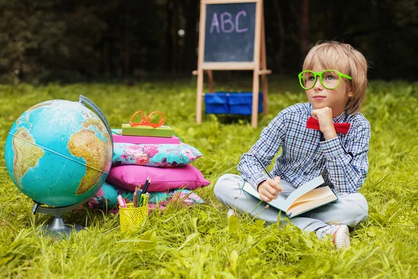 Pequeño y elegante chico rubio con gafas de aprendizaje —  Fotos de Stock