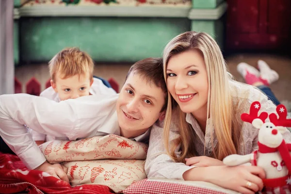 Мама, папа и сын лежат на подушках. Концепция новогодних и рождественских праздников — стоковое фото