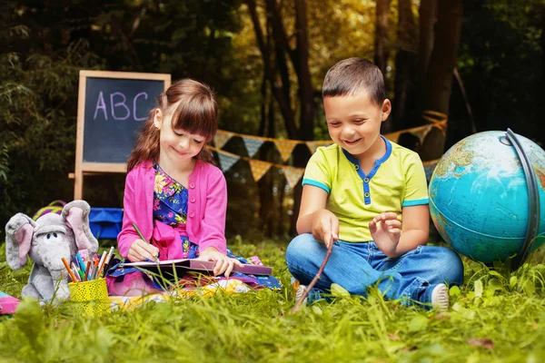 Lustige kleine Kinder, ein Junge und ein Mädchen gemalt. Bildung und Schulkonzept. — Stockfoto