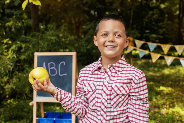 Schulkind lächelnd schöner Junge mit Apfel. das Konzept von Schule und Bildung — Stockfoto