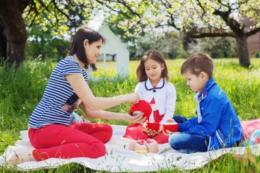 Anne ve kızı ve oğlu pikniğe çay içme