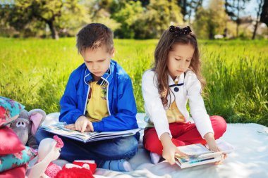 kardeş parkta bir kitap okuma