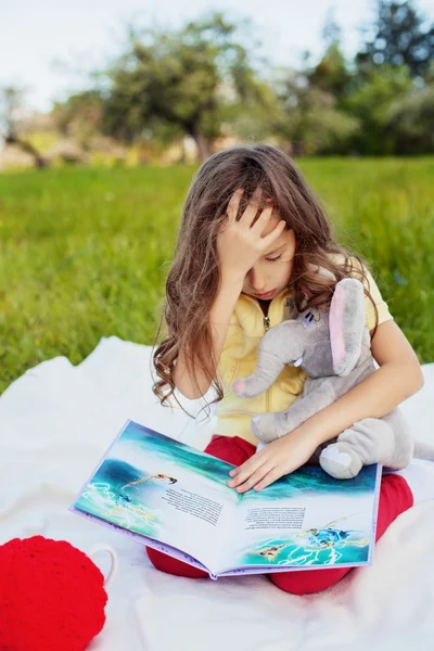 Грустный ребенок с книгой — стоковое фото
