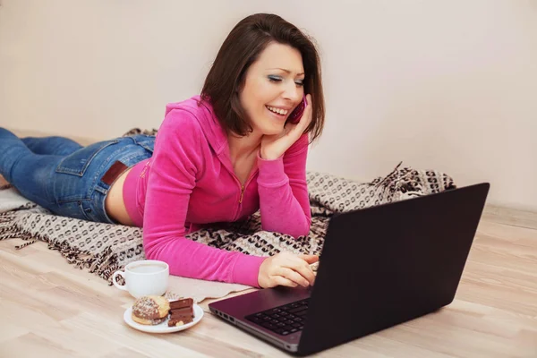 Mulher bonita está rindo e olhando para um laptop — Fotografia de Stock