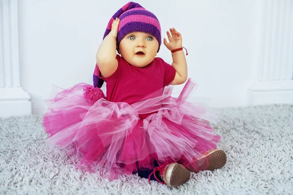 Beautiful baby in the cap and skirt. The concept of parenting. — Stock Photo, Image