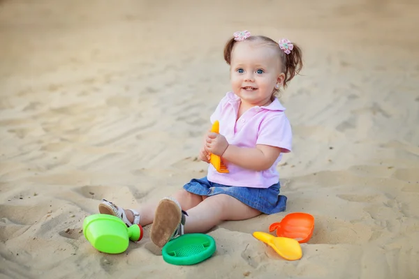 Niña juega con juguetes en la arena. El concepto de educatio — Foto de Stock