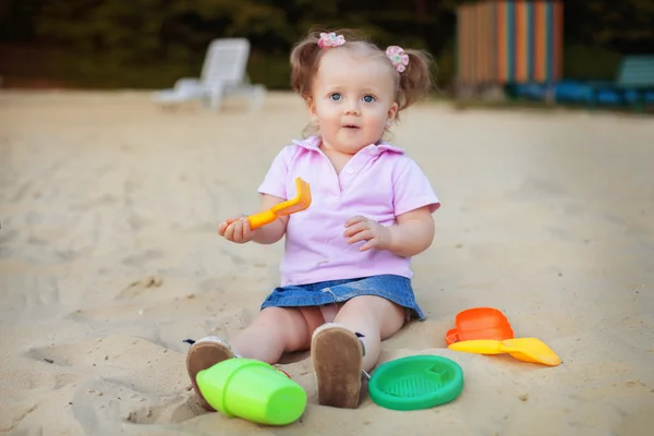 Pequeño bebé juega con juguetes en la arena. El concepto de educatio — Foto de Stock