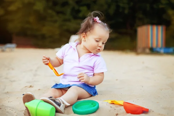 Bebé niña jugando en los juguetes de caja de arena. El concepto de chi — Foto de Stock