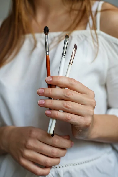 Una Mujer Sostiene Varios Pinceles Maquillaje Sus Manos Una Artista — Foto de Stock