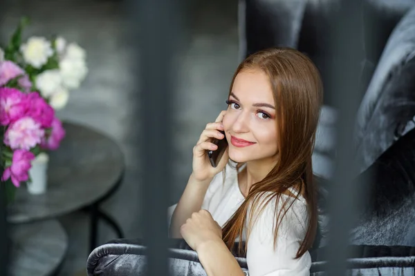 Mulher Ruiva Jovem Falando Telefone Celular Enquanto Sentado Sofá Veludo — Fotografia de Stock