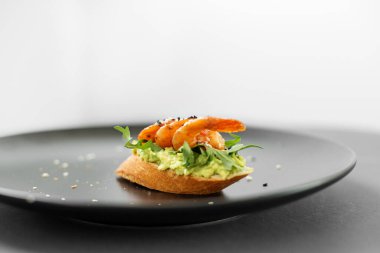 Sağlıklı vejetaryen yemeği. Avokado, deniz ürünleri ve büfeden bir tabakta karidesli sandviç.