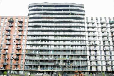 Çoklu cam balkon, çağdaş mimari ve tuğla ve beyaz dış tasarım elementlerinin karışımına sahip yüksek konutlar..