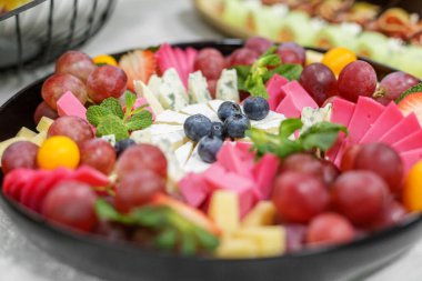 Peynirli, peynirli, mavi peynirli, üzümlü, çilekli ve yaban mersinli renkli bir tabak. Yemek servisi, açık büfe ya da şarap tatma için mükemmel..