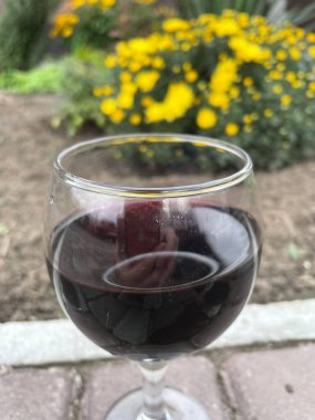 Tahta bir masada bir kadeh kırmızı şarap.