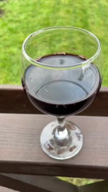 Bahçedeki masada, bardakta kırmızı şarap, doğa.