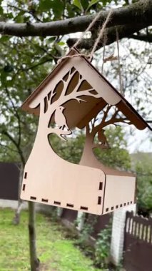 bird feeder on a tree in a Ukrainian autumn garden, tiny plywood house