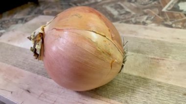 Tahtanın üzerinde büyük ve küçük bir soğan yatıyor.