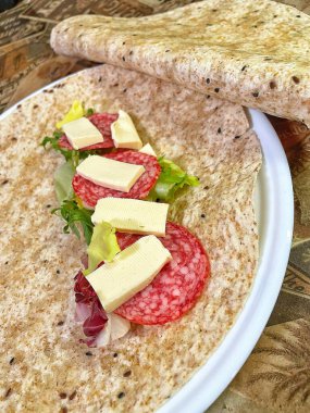 Lavaş tabakları, lavaş tortilla, işlenmiş peynir, sosis, yeşillik.