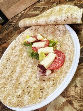 Lavaş tabakları, lavaş tortilla, işlenmiş peynir, sosis, yeşillik.