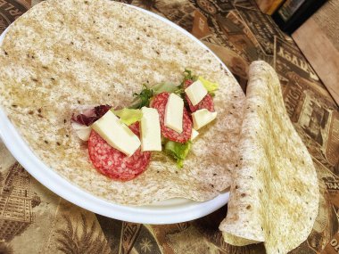 Lavaş tabakları, lavaş tortilla, işlenmiş peynir, sosis, yeşillik.