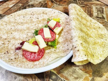 Lavaş tabakları, lavaş tortilla, işlenmiş peynir, sosis, yeşillik.