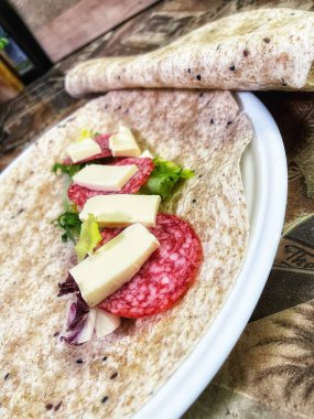 Lavaş tabakları, lavaş tortilla, işlenmiş peynir, sosis, yeşillik.