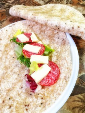 Lavaş tabakları, lavaş tortilla, işlenmiş peynir, sosis, yeşillik.