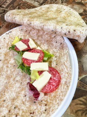 Lavaş tabakları, lavaş tortilla, işlenmiş peynir, sosis, yeşillik.