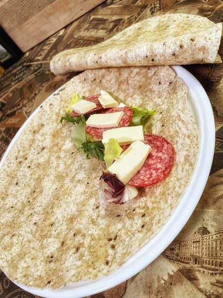 Lavaş tabakları, lavaş tortilla, işlenmiş peynir, sosis, yeşillik.