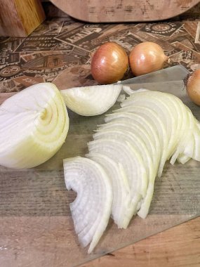 Tahta kesme tahtasında dilimlenmiş beyaz soğan.